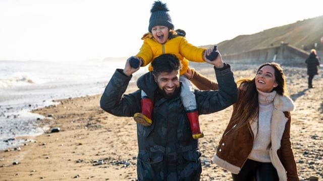 Family walking on beach in winter